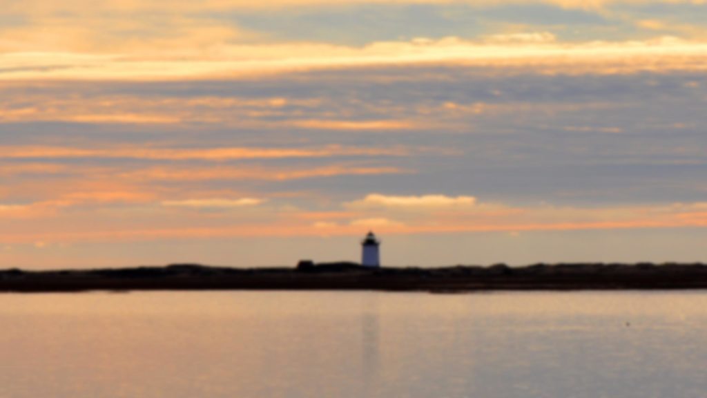 A lighthouse against a Cape Cod sunset